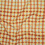 Close up of printed linen with graphic plaid pattern in red, orange, yellow and aqua blue.