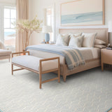 Coastal bedroom setting in blues and beige, with a blue Bellamar area rug.