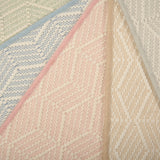 Stack of broadloom carpets in a dimensional herringbone stripe pattern in an array of pastel colors. 