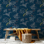 A bench and basket stand in front of a wall papered in a playful hand-drawn animal print in shades of white, pink and navy.