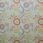 Printed fabric with a whimsical floral pattern in blue, yellow and orange with dark brown stems on a soft blue background. 