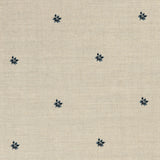 Detail of a printed linen fabric in a repeating small-scale flower pattern in navy on a cream field.