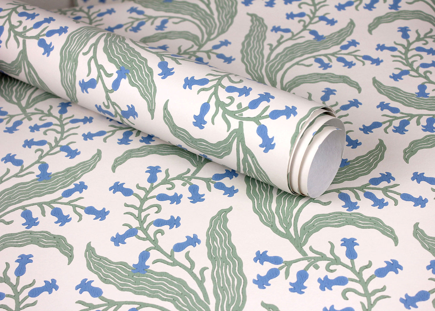 Wallpaper roll in a scrolling floral pattern in blue and green on a cream field. 