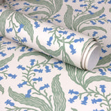 Wallpaper roll in a scrolling floral pattern in blue and green on a cream field. 