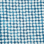 Detail of fabric in a circular floral print in light blue and white on a mottled blue field.