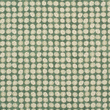 Detail of fabric in a circular floral print in light green and white on a mottled green field.