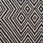 Handwoven rug in tan and navy blue in a diamond stripe design. 
