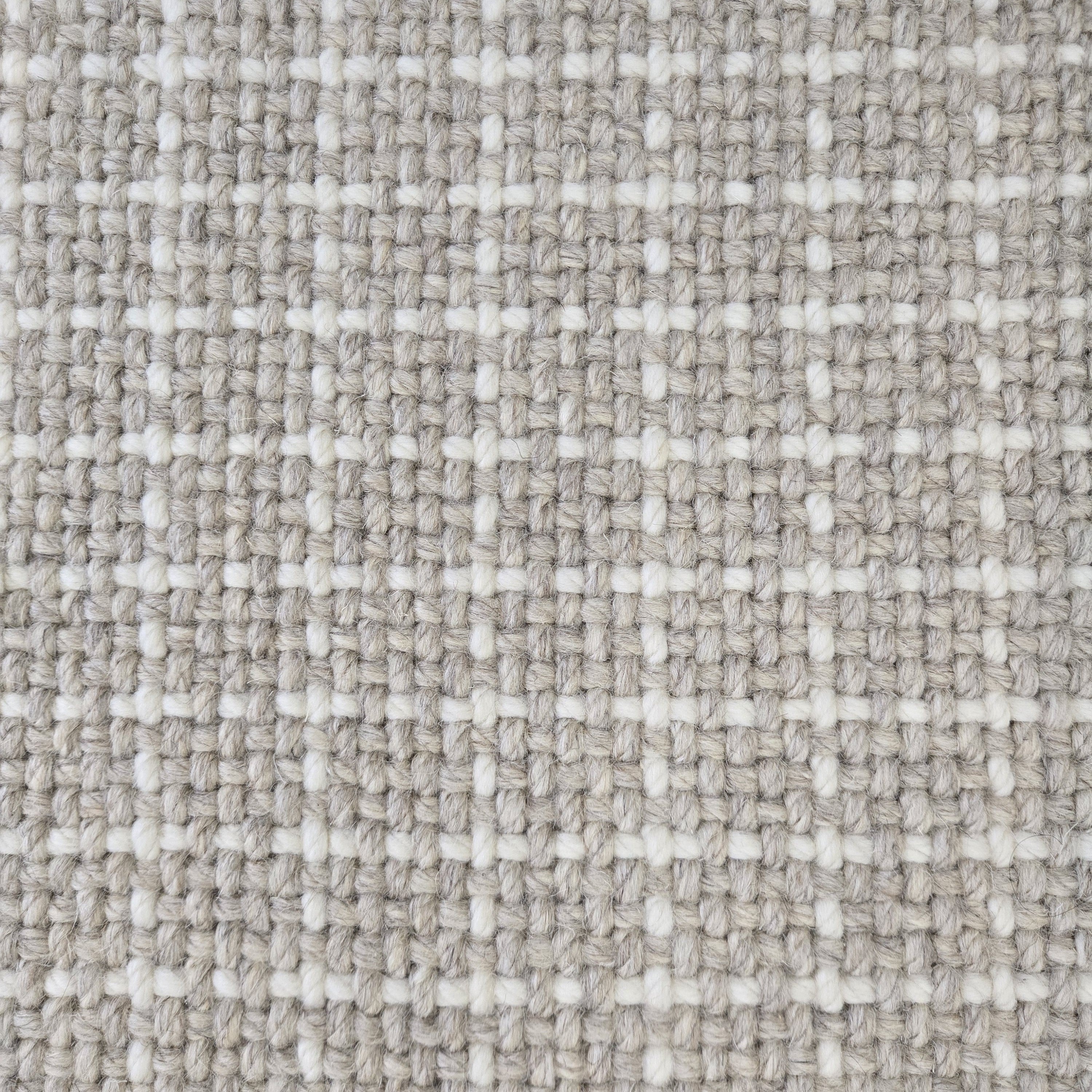 Close-up of a carpet with a textured check pattern in grey and white.