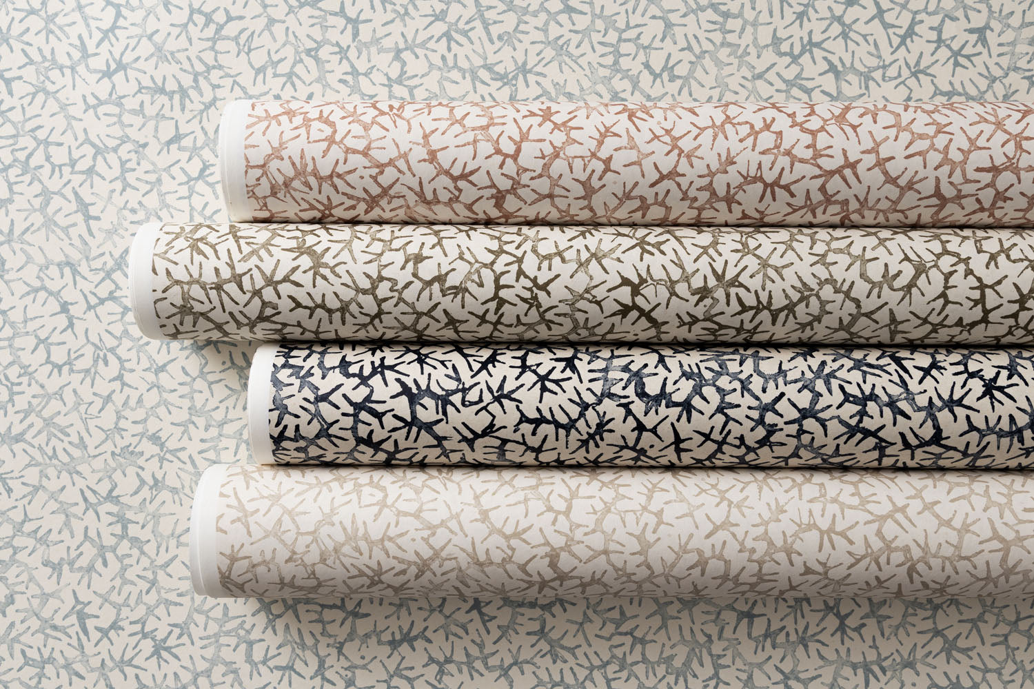 Rolls of wallpaper in watercolor coral design in various colors. 