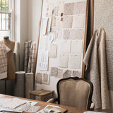 Studio desk setting with textile designs in progress featuring a coral watercolor pattern. 