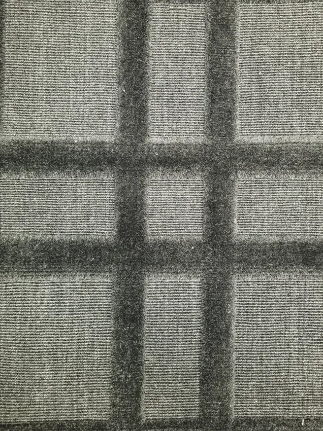 Broadloom carpet in a dimensional plaid pattern in grey.