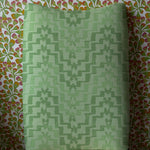 Upholstered dining chair in bold green stripe against floral wallpaper
