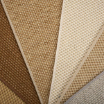 Close-up of broadloom carpet samples in brown, beige, and gray.