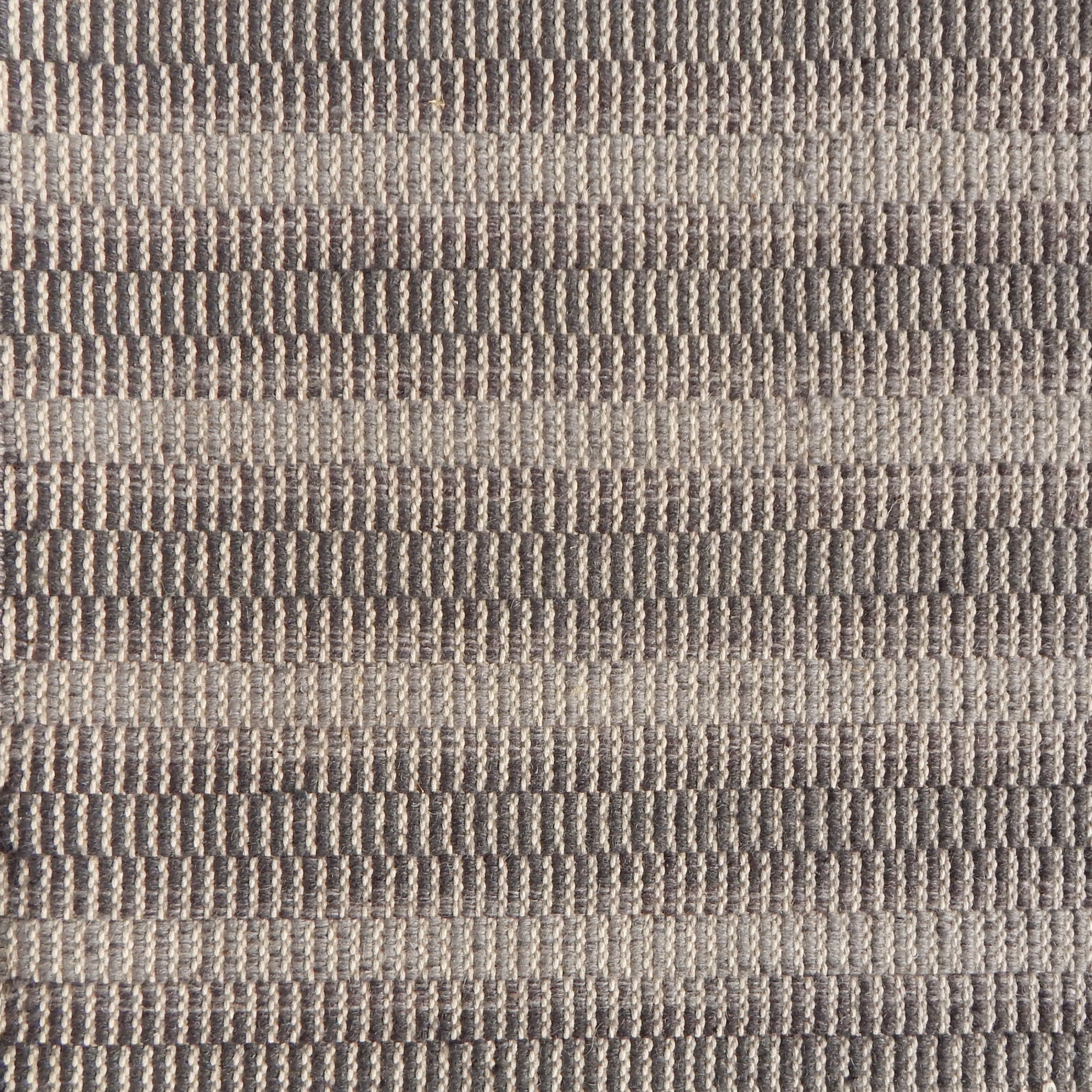 Flatweave rug in a textural stripe in shades of brown.