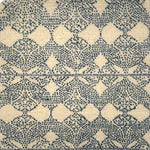 Handknotted rug with dotted geometric motif in blue on a cream field. 