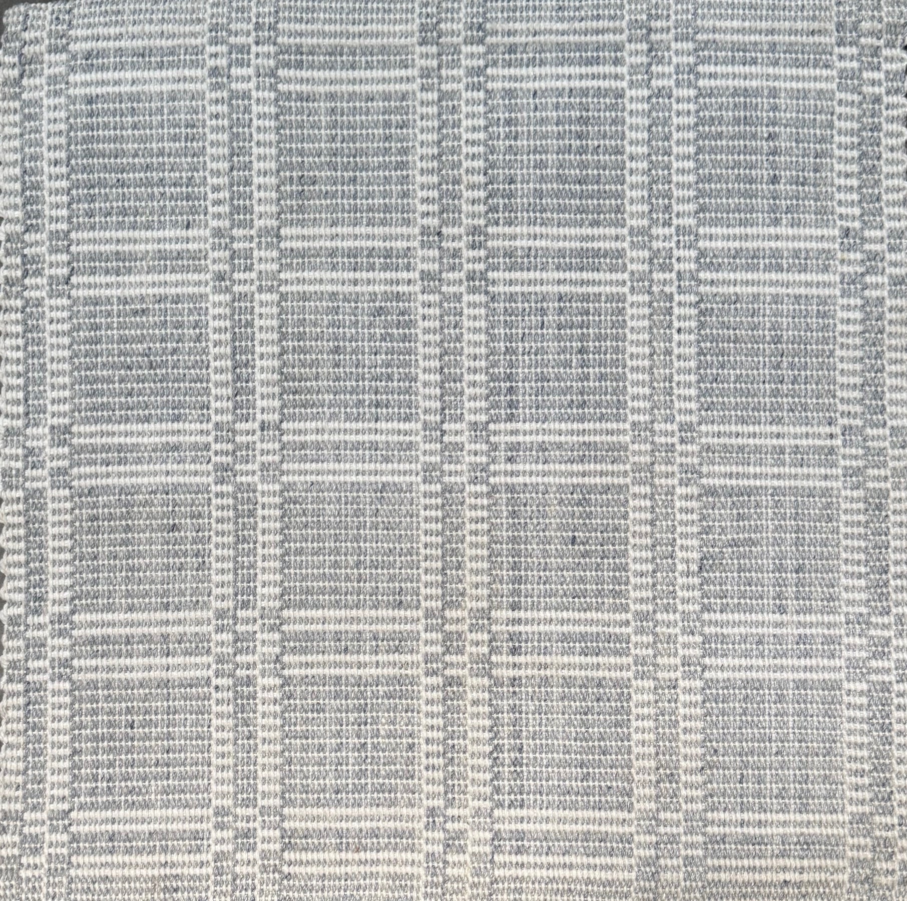 Woven rug in a plaid check in slate blue and white. 
