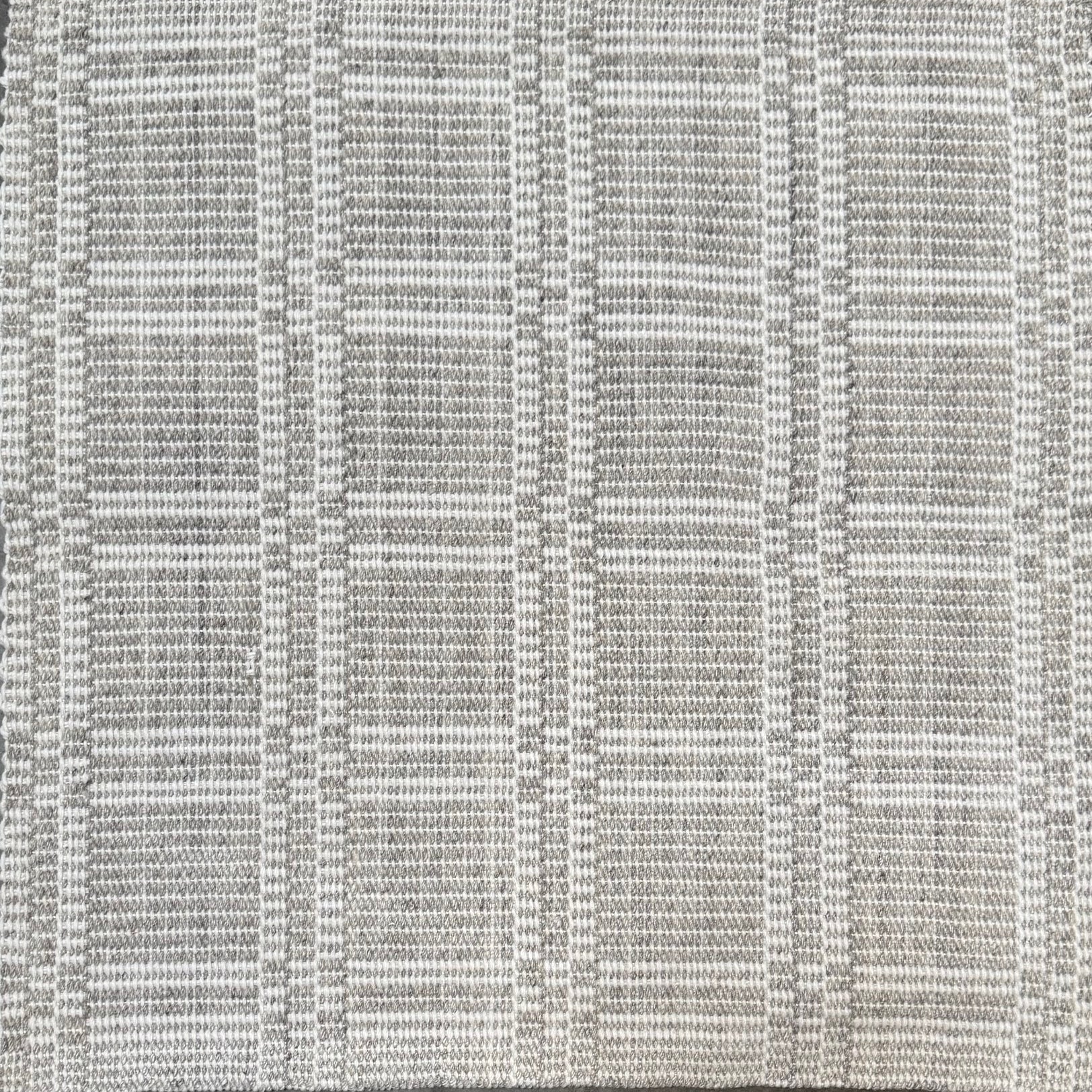 Woven rug in a plaid check in grey and white. 