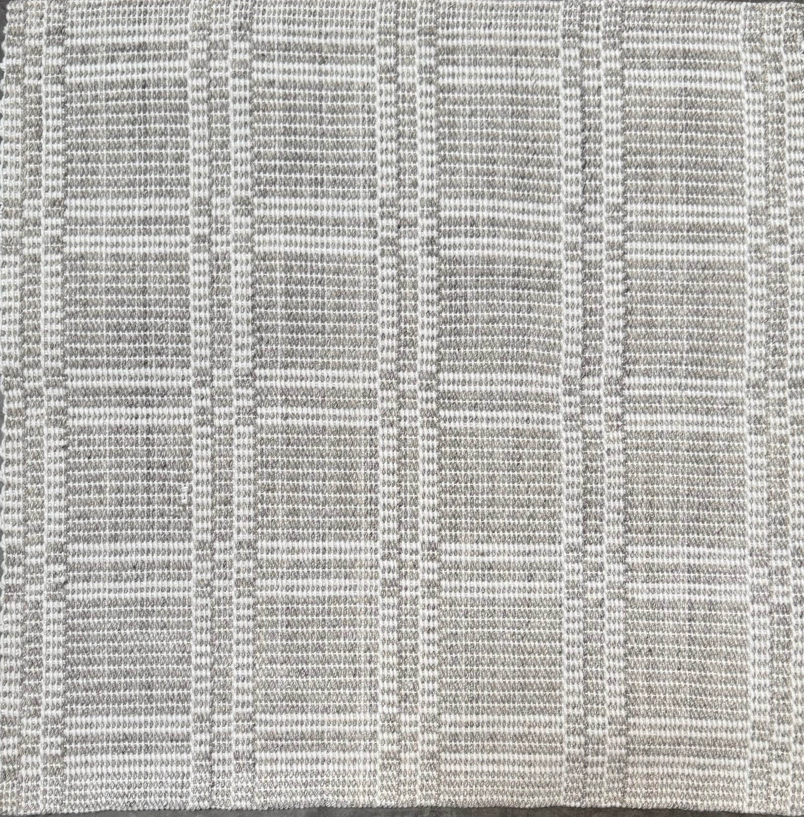 Woven rug in a plaid check in grey and white. 