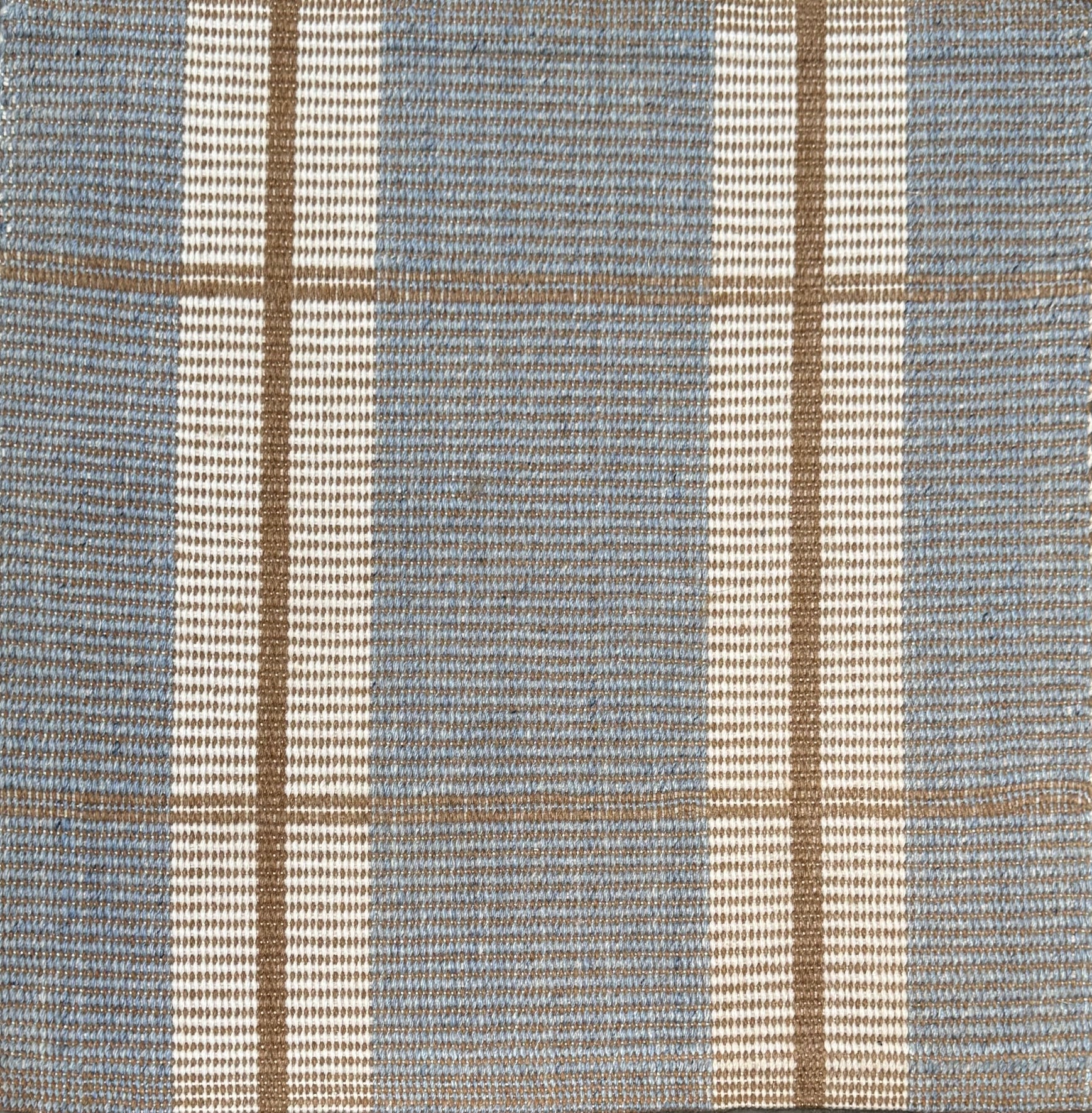 Woven rug with plaid pattern in blue, beige, and white
