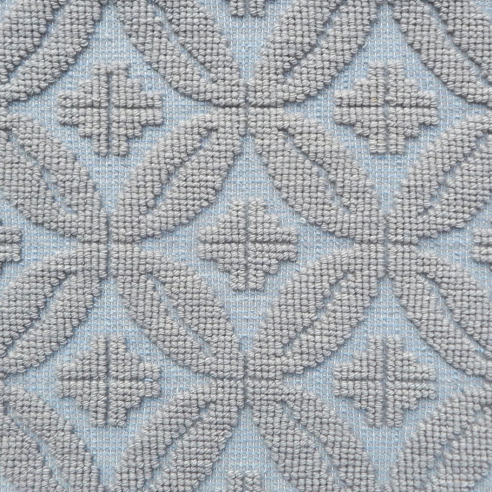 Handmade rug with classic circle lattice design in grey on a blue field. 
