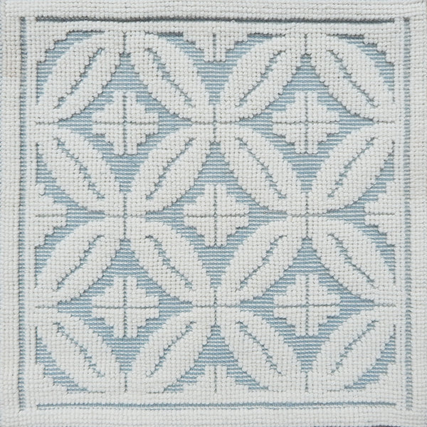 Handmade rug with classic circle lattice design in white on a blue field. 