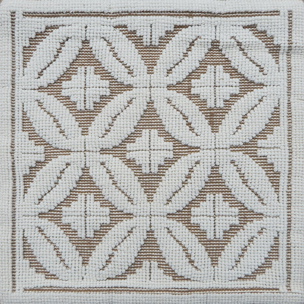 Handmade rug with classic circle lattice design in white on a tan field. 