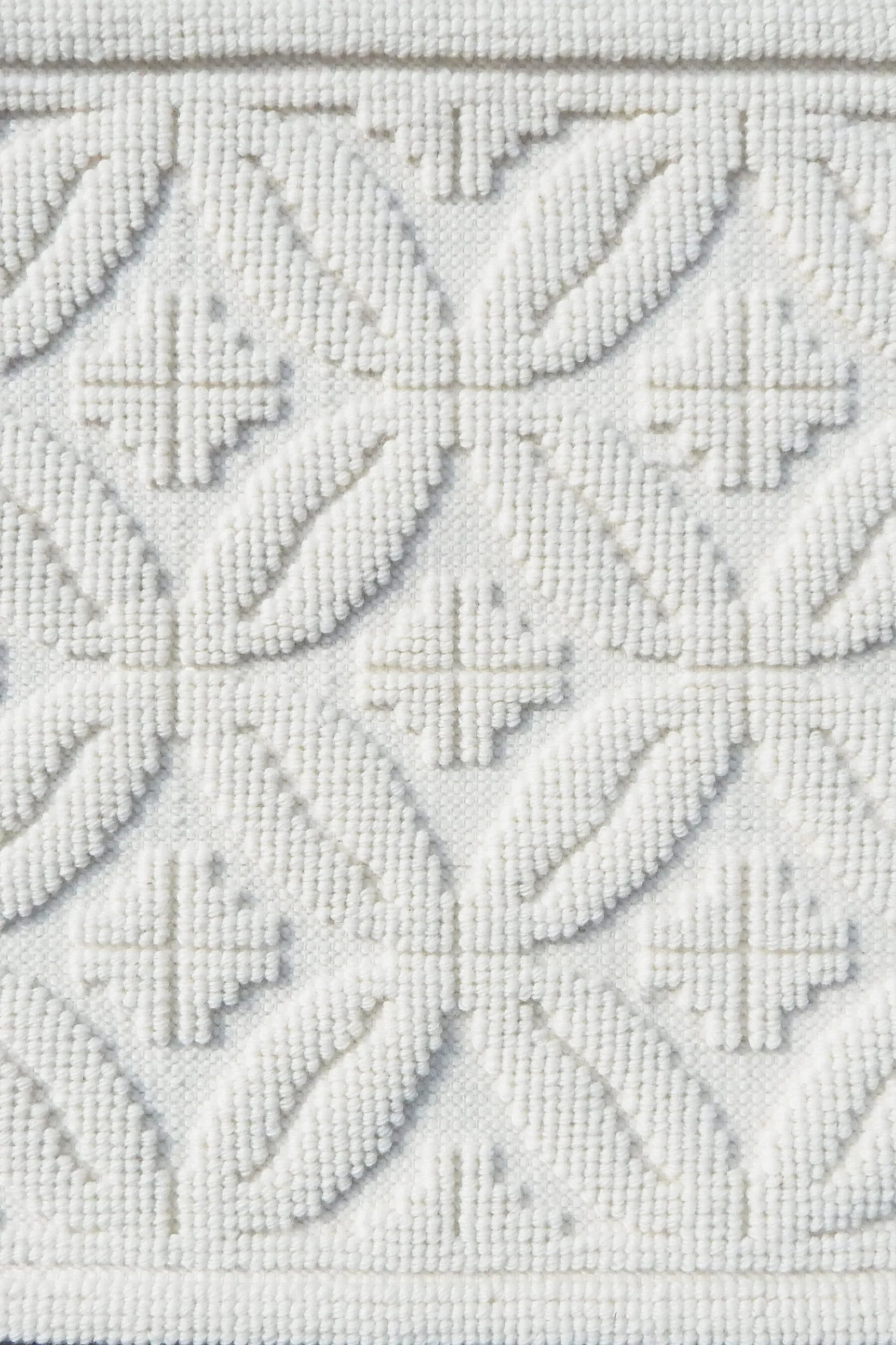 Handmade rug with classic circle lattice design in white. 