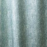 Draped linen in a painterly small-scale dashed dot print in white on a soft peacock blue watercolor field.