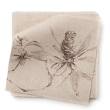 A stack of fabric swatches in a painterly pine cone and branch print in brown on a cream field.