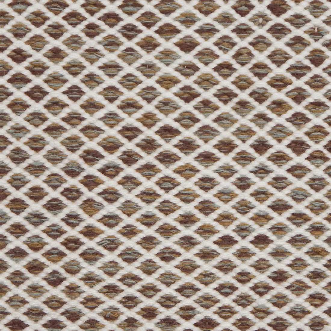 Handwoven rug with small scale diamond lattice in cream on a brown field. 