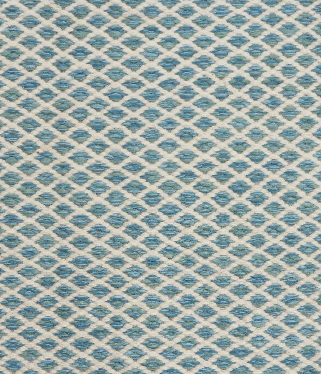 Handwoven rug with small scale diamond lattice in cream on a tan and marine blue field. 