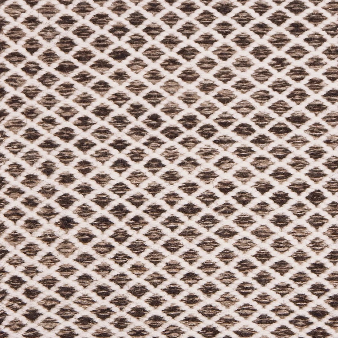 Handwoven rug with small scale diamond lattice in cream on a brown field. 