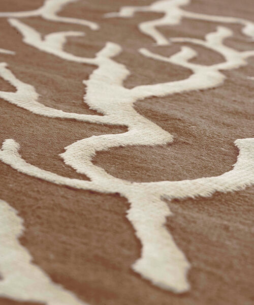 Close-up of a textured brown and beige rug with wavy pattern