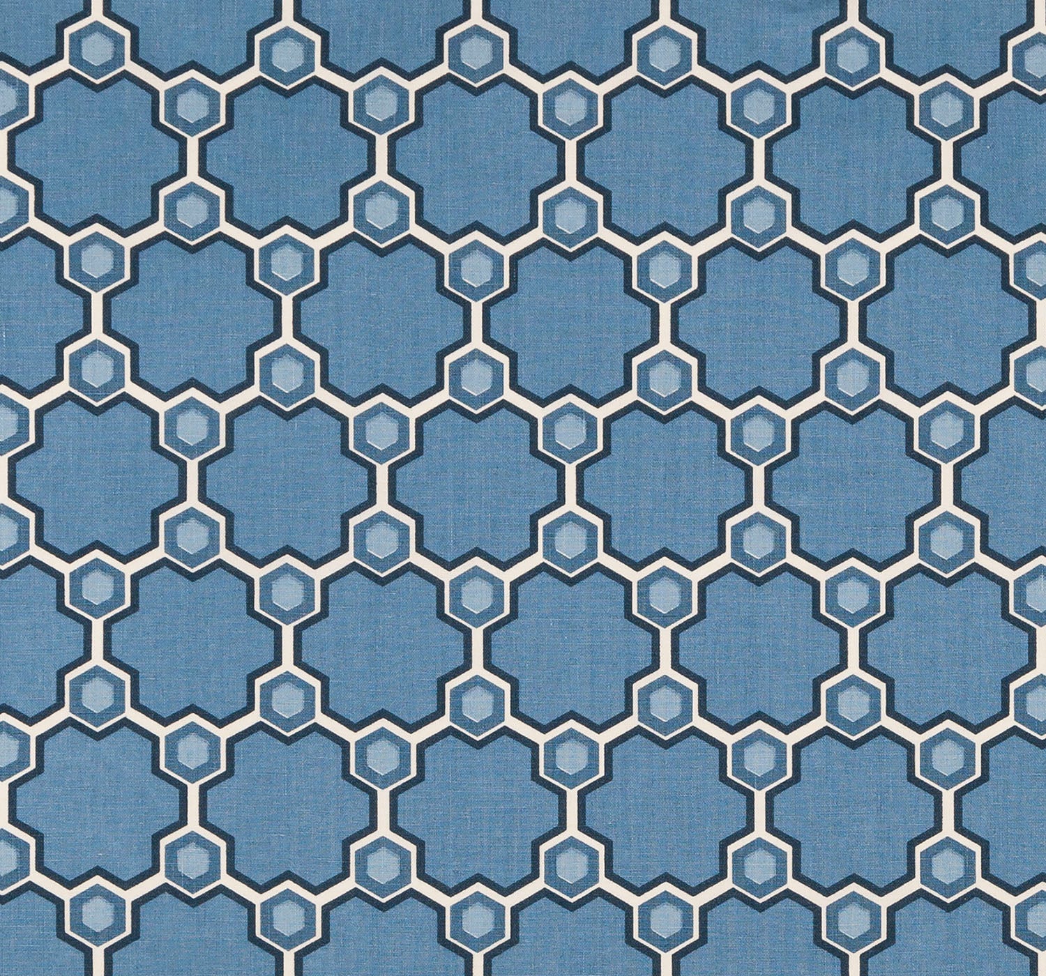 Detail of fabric in a geometric honeycomb pattern in shades of blue, cream and charcoal.