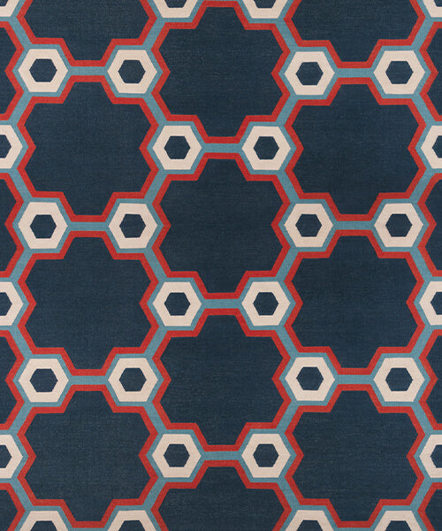 Flatwoven rug in a bold geometric floral-like design in blue, navy, red and cream. 