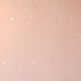 Detail of a wallpaper in a random splattered pattern in metallic cream on a pink field.