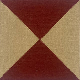 Close-up of a flatweave rug with a diamond pattern in red and cream