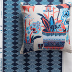 A square throw pillow with a colorful botanical and vase pattern, displayed against a navy blue diamond stripe wallpaper backdrop. The pillow features a cream base with blue, coral red, and navy floral motifs.