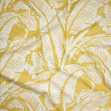 Yellow and white tropical banana leaf pattern fabric shown in a close-up, draped view.