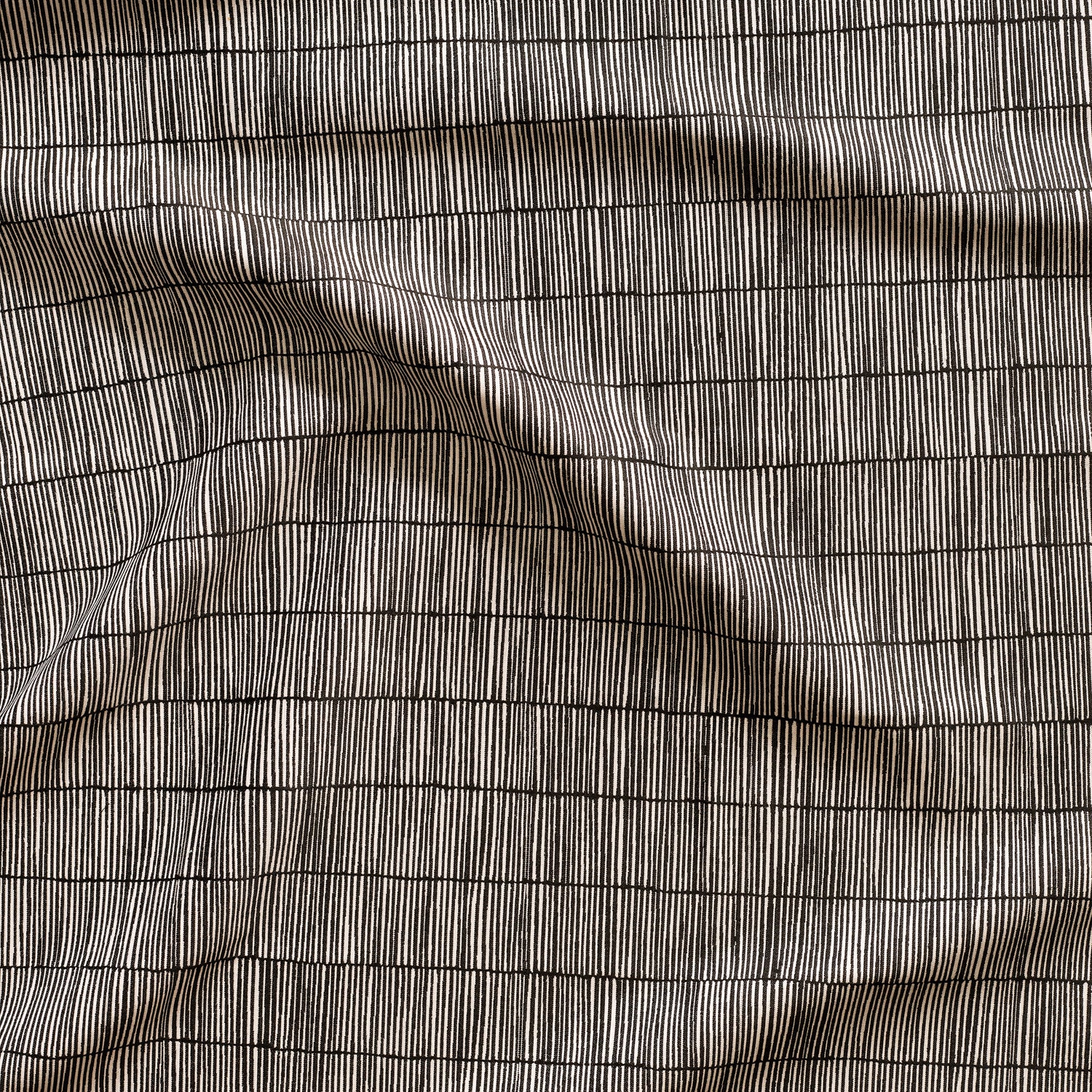 Close up of gently draped woven Indoor-Outdoor fabric with thin hand drawn stripe grid in white on black. 