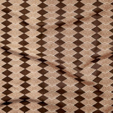 Close up of gently draped printed linen with linear stacked diamond stripe in shades of brown.