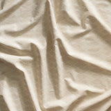 Close up of gently draped printed linen with linear stacked diamond stripe in shades of ecru.
