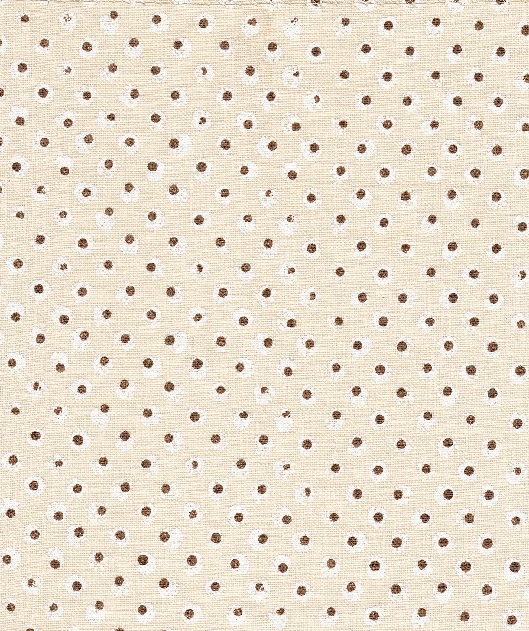 Detail of fabric in a painterly dot print in white and brown on a cream field.