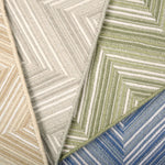 Broadloom carpet in zig zag pattern in tan, grey, green and blue. 