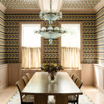 Dining room with patterned wallpaper, chandelier, and table set.