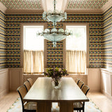 Dining room with patterned wallpaper, chandelier, and table set.