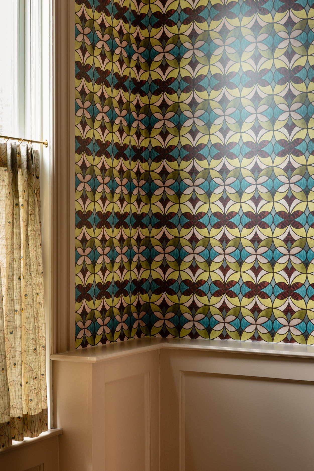 Room with a colorful geometric patterned wallpaper on the wall.
