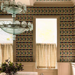 Dining room with patterned wallpaper, chandelier, and window light.