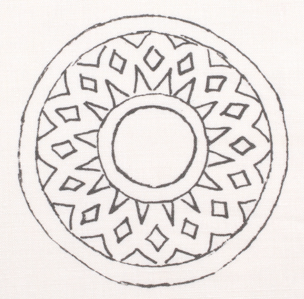 Detail of fabric in a repeating circular geometric print in gray on a white field.