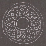 Detail of fabric in a repeating circular geometric print in light gray on a charcoal field.